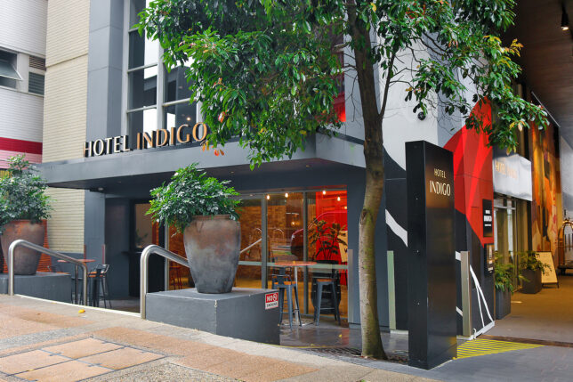 a building with a tree and a sign