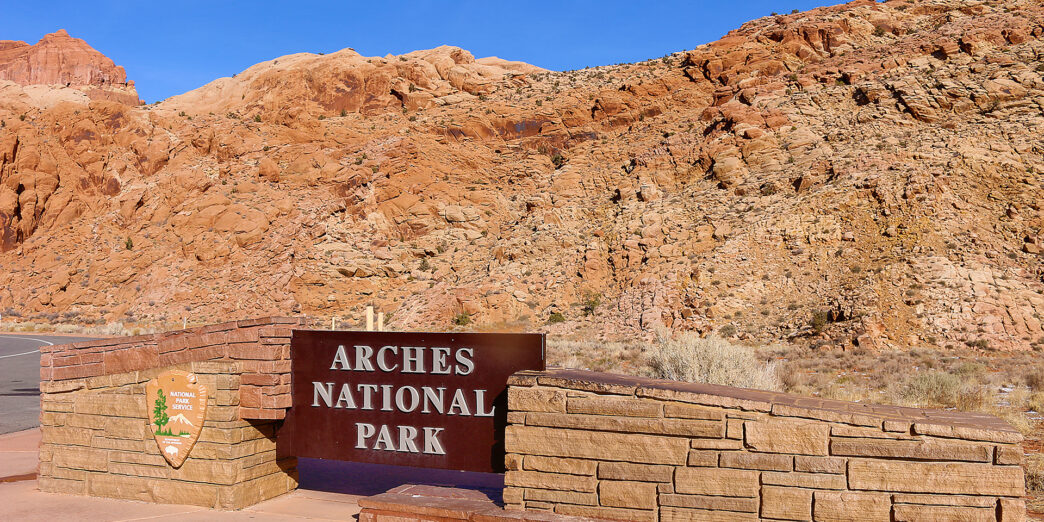 a sign in front of a rocky hill