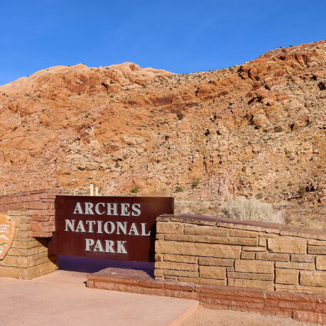 a sign in front of a rocky hill