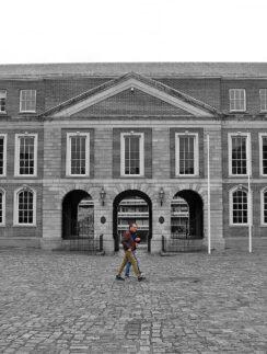 a man walking in front of a large building