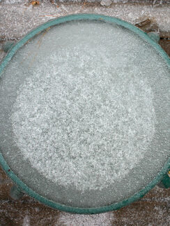 a round glass table with ice on top