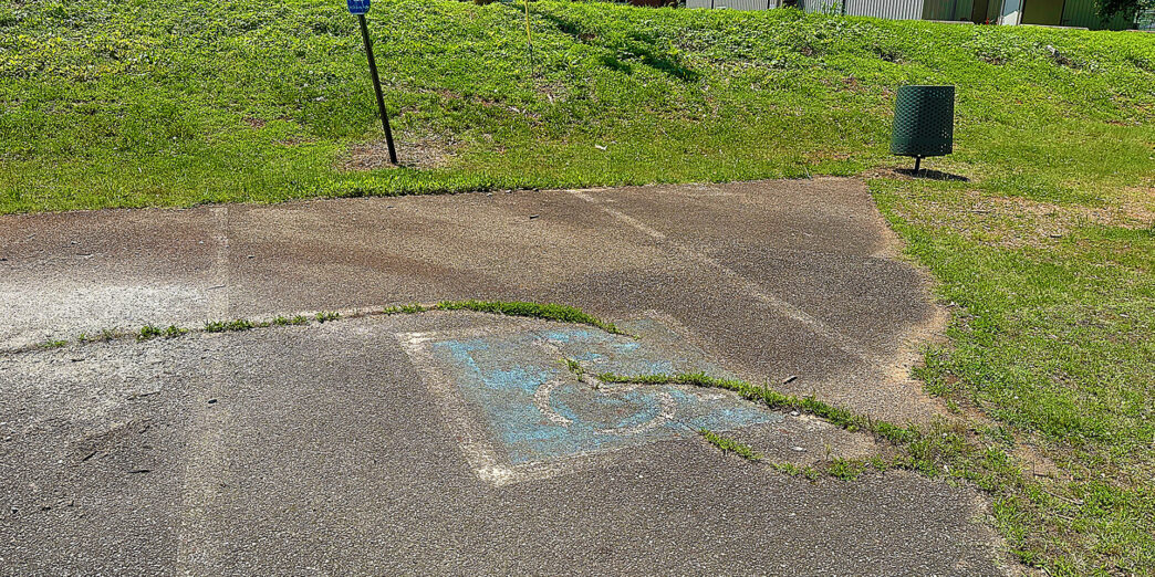 a concrete driveway with a hole in the ground