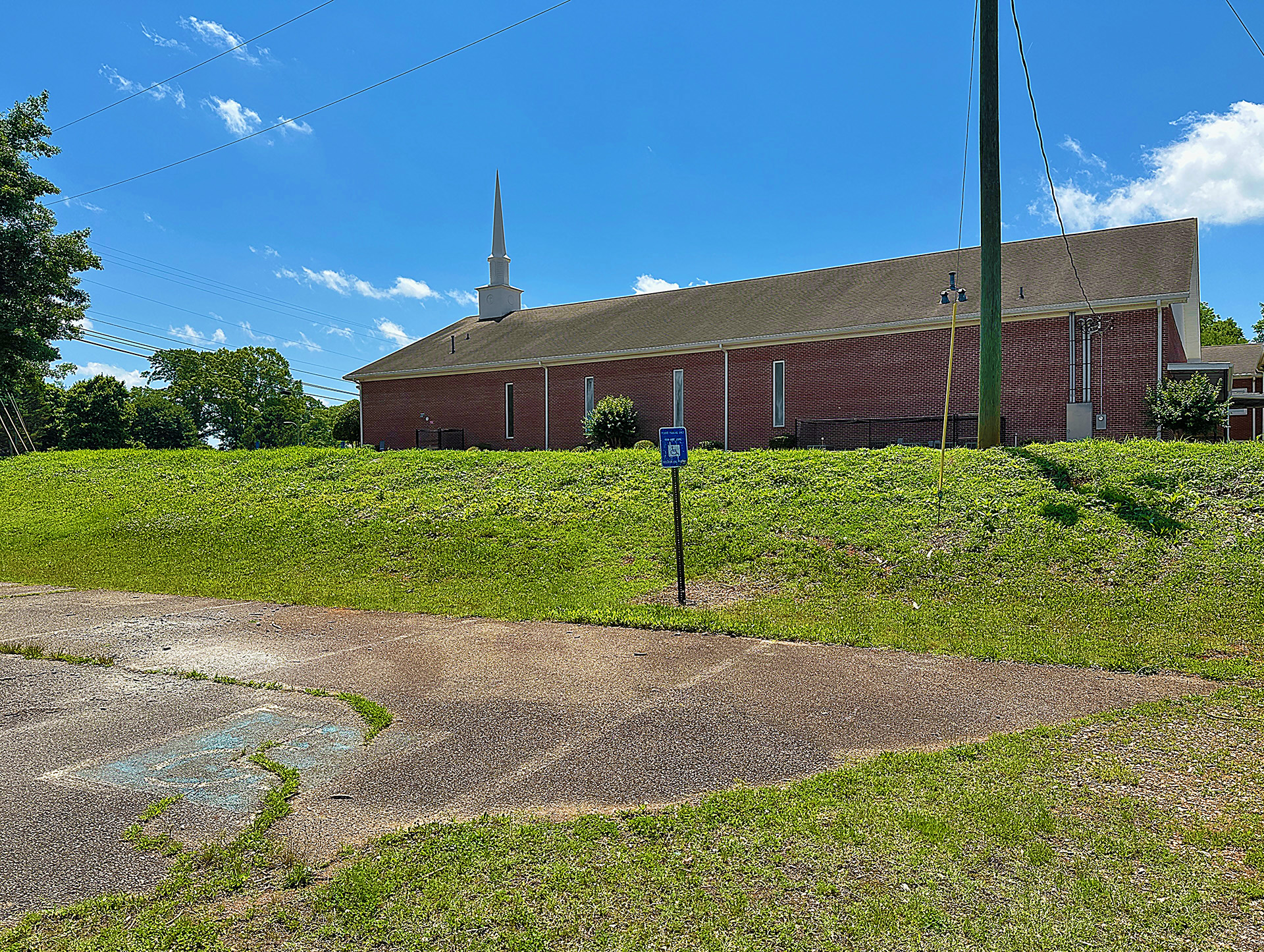 a brick building with a lawn and a sign
