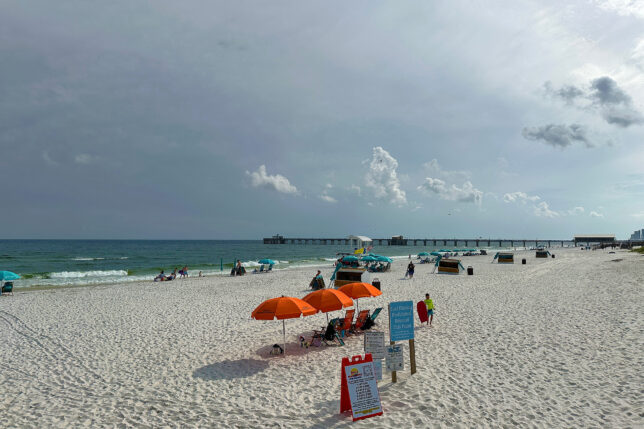 a beach with umbrellas and people on it