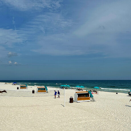 people on a beach with people and umbrellas