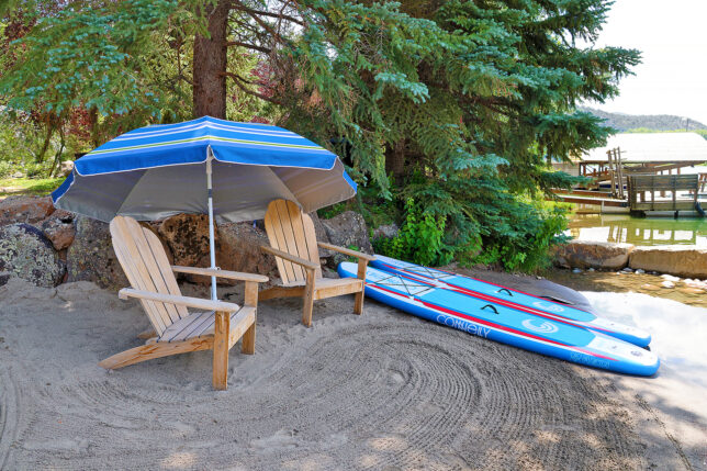 a beach chair and surfboard under an umbrella
