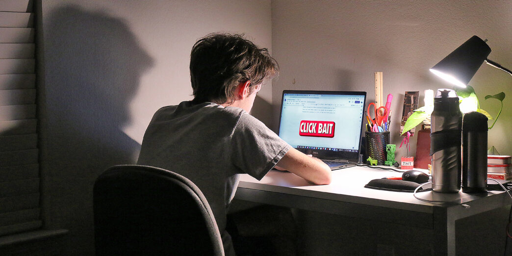 a man sitting at a desk with a laptop