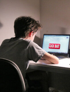 a man sitting at a desk with a laptop
