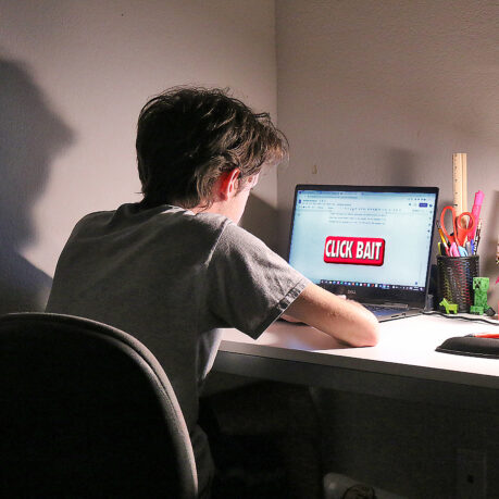 a man sitting at a desk with a laptop