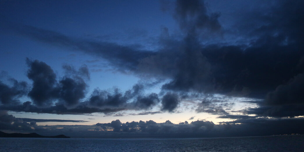 a body of water with clouds in the sky