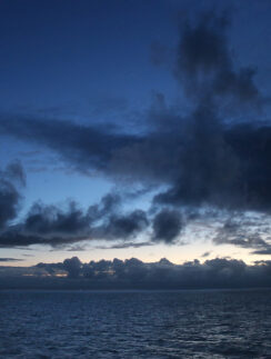a body of water with clouds in the sky