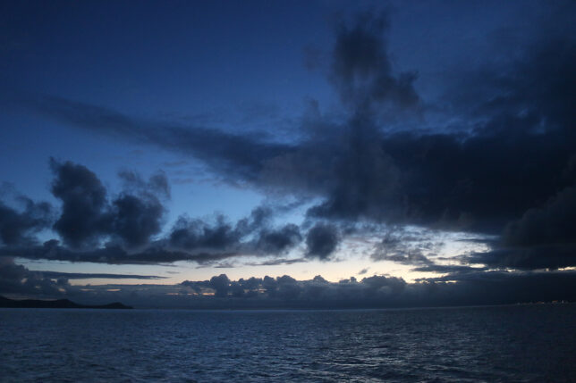 a body of water with clouds in the sky