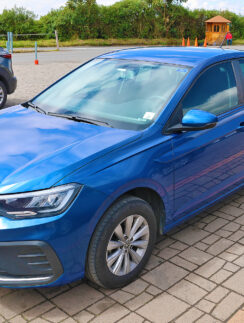 a blue car parked on a brick surface