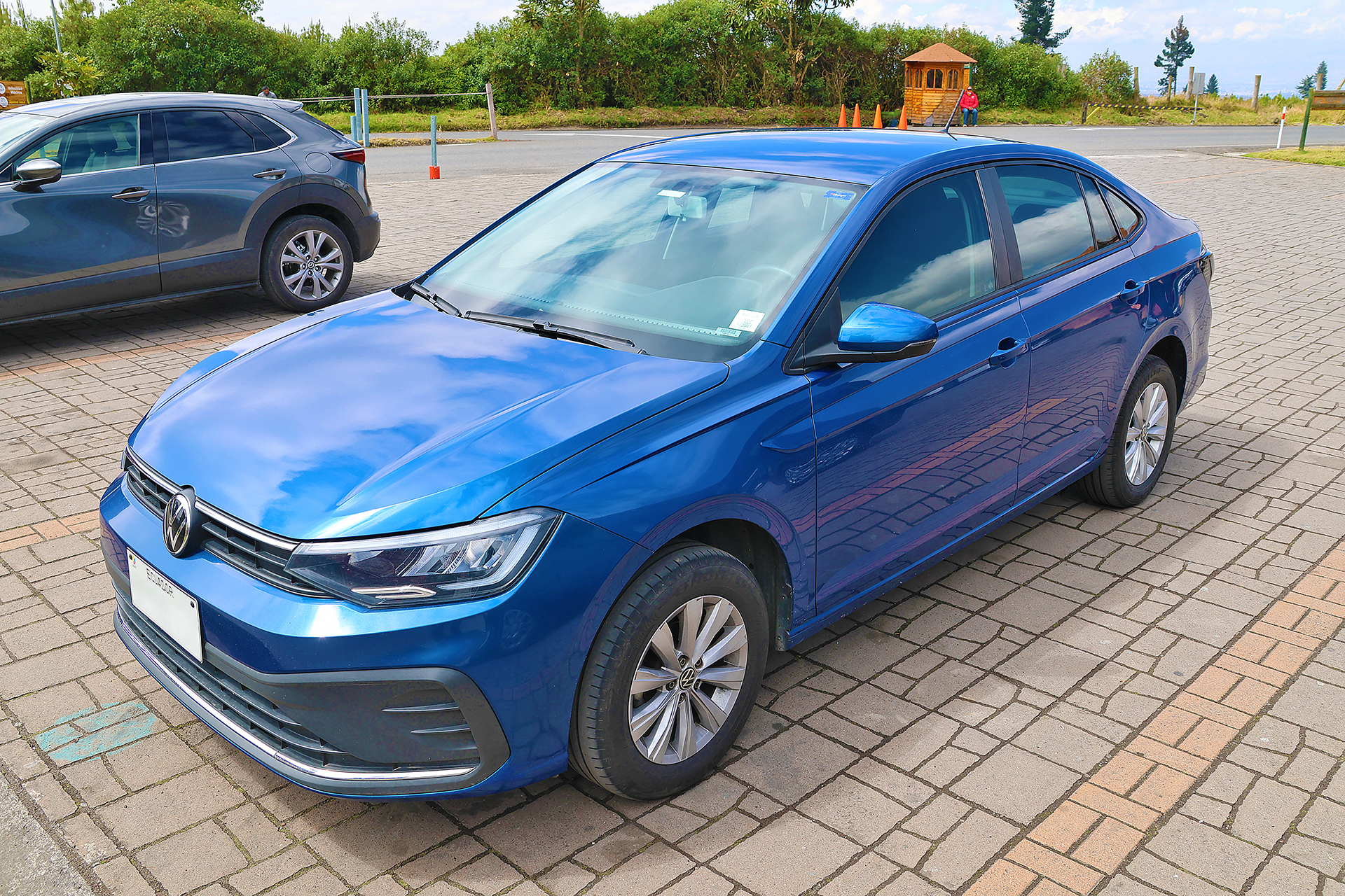 a blue car parked on a brick surface