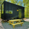 a black trailer with a picnic table in the woods