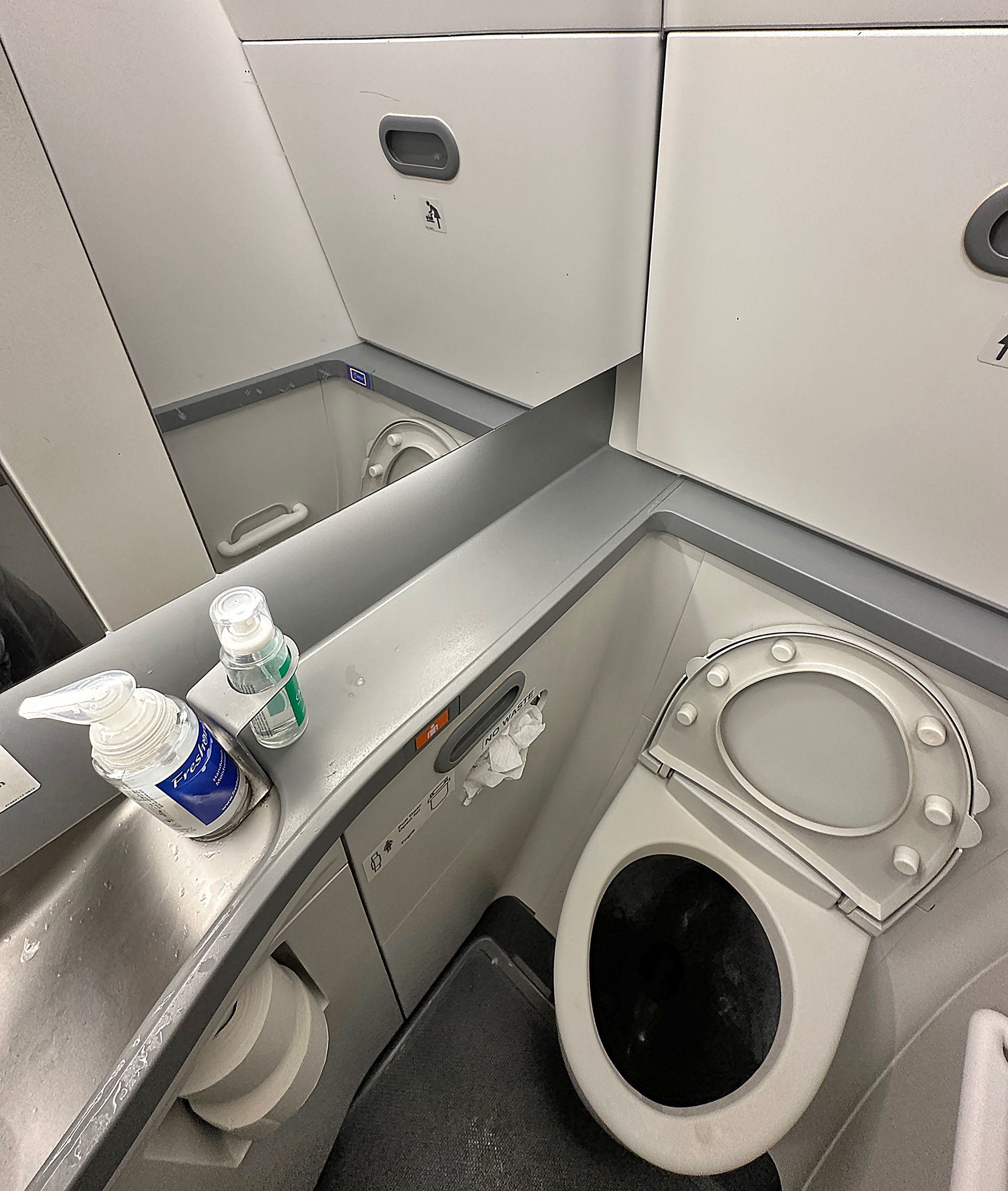 a bathroom with a toilet and a mirror