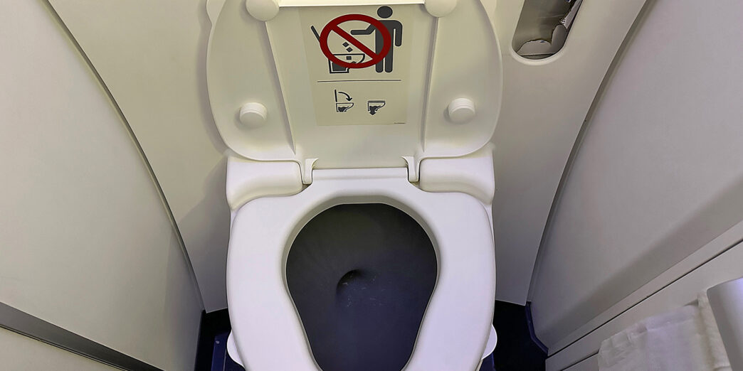 a toilet with a sign on the seat
