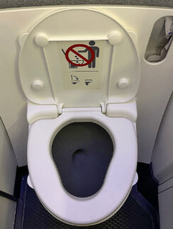a toilet with a sign on the seat