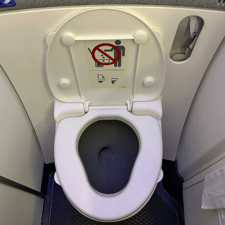 a toilet with a sign on the seat