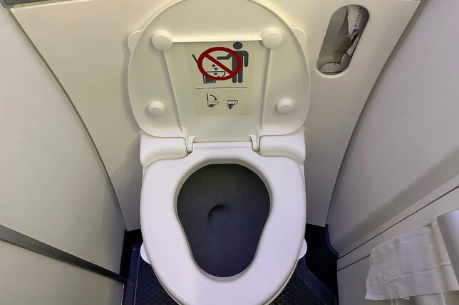a toilet with a sign on the seat