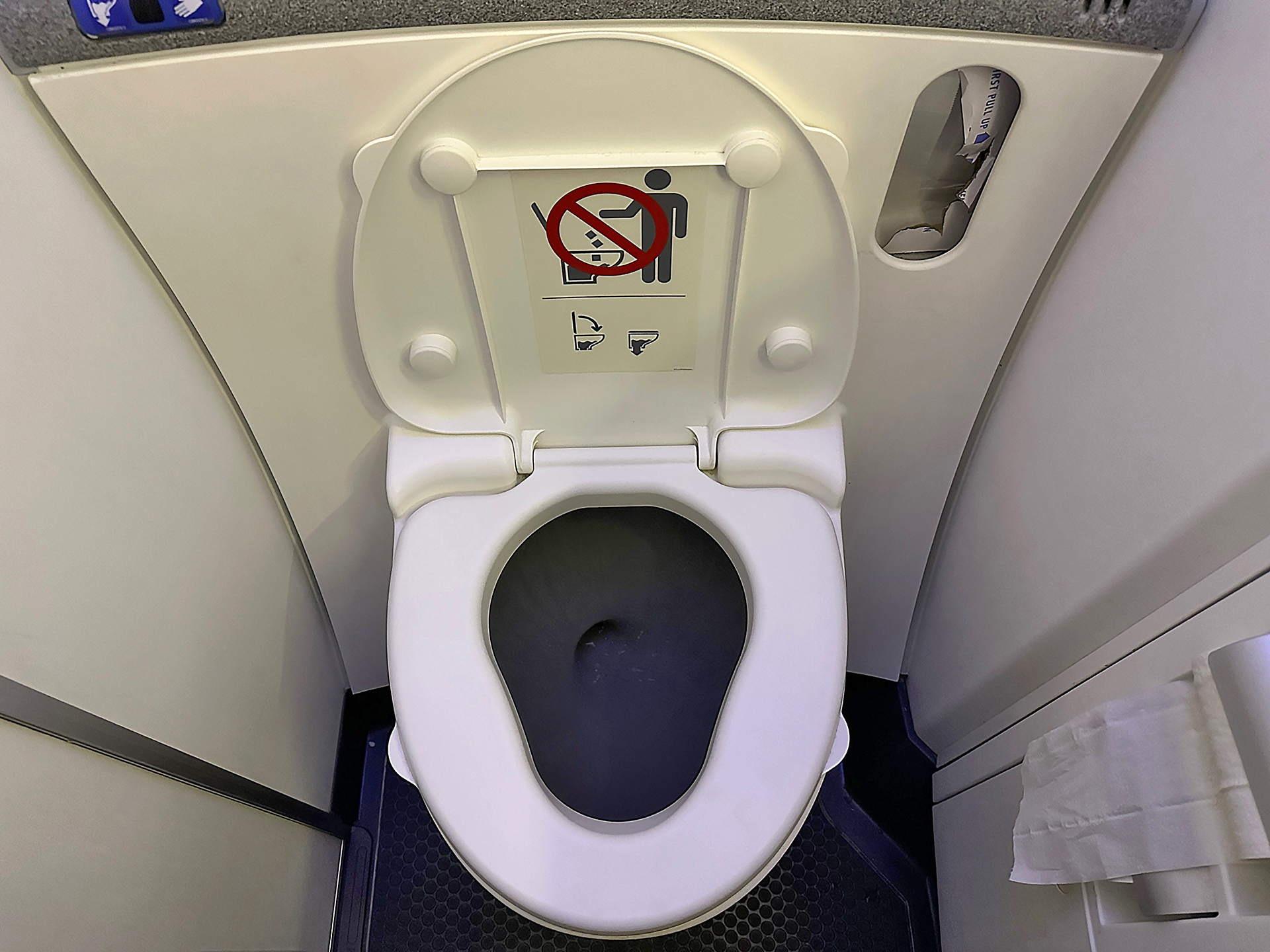 a toilet with a sign on the seat