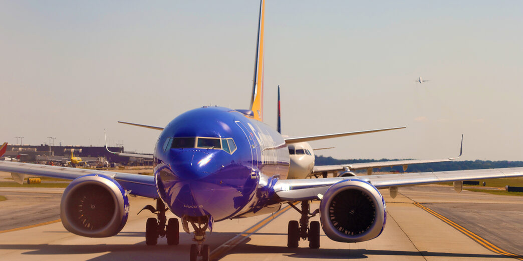 a blue airplane on a runway