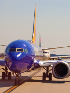a blue airplane on a runway