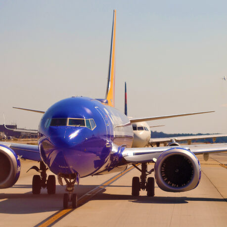 a blue airplane on a runway