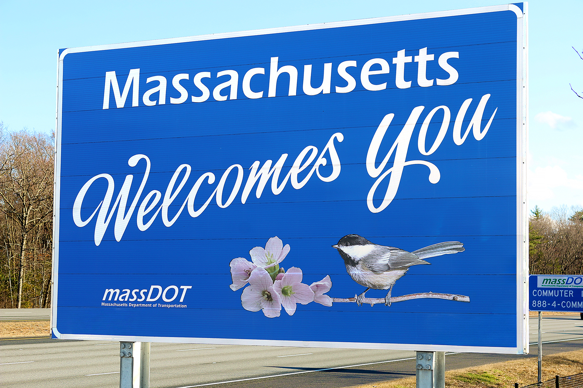 a blue sign with a bird and flowers on it