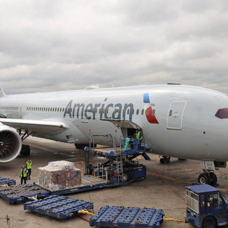 a plane with luggage being loaded with luggage