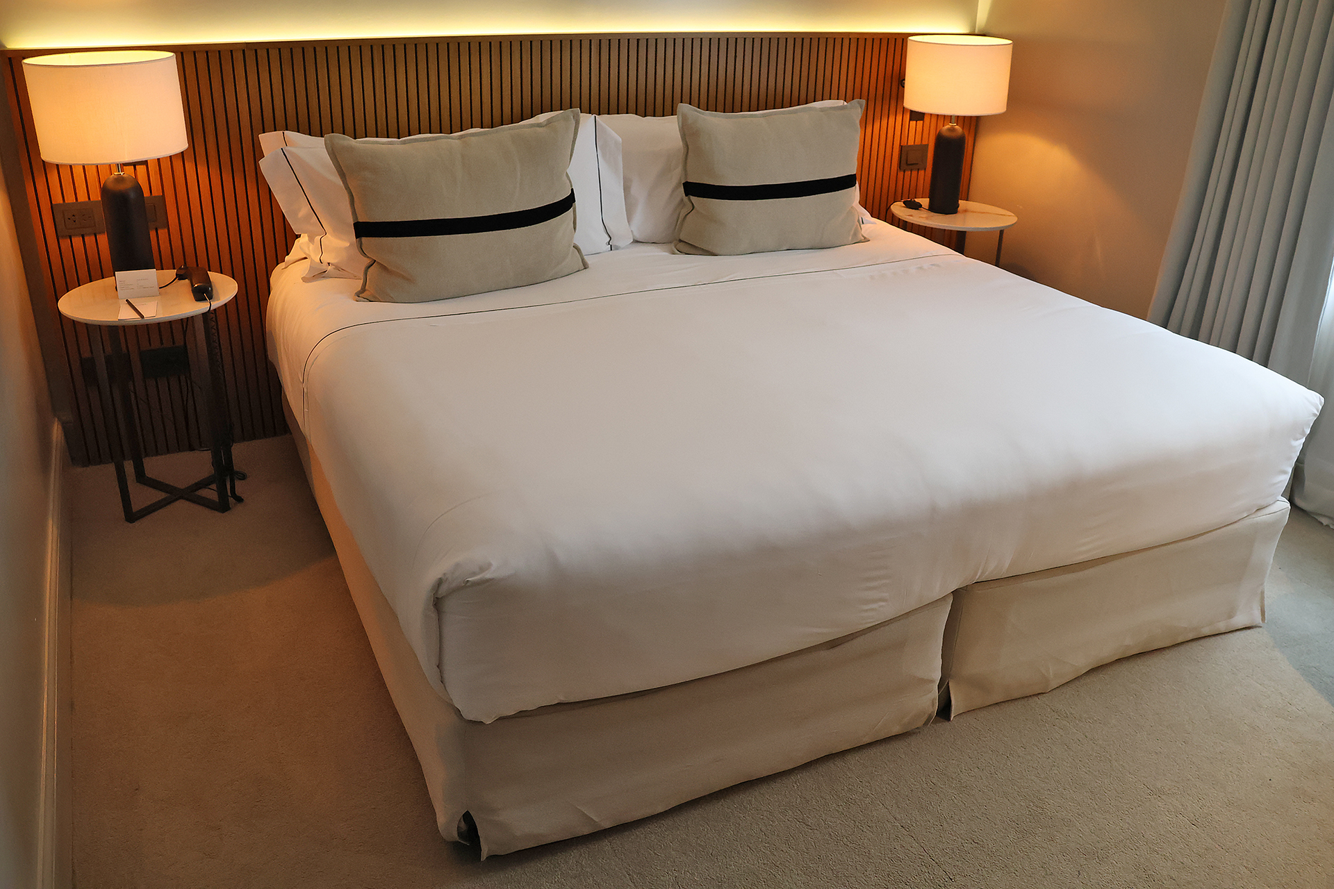 a bed with white sheets and a lamp