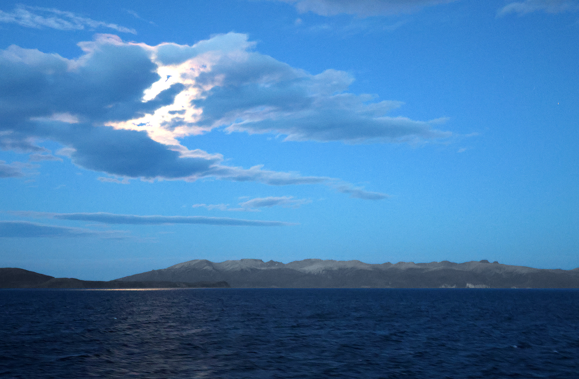 a body of water with a mountain in the distance