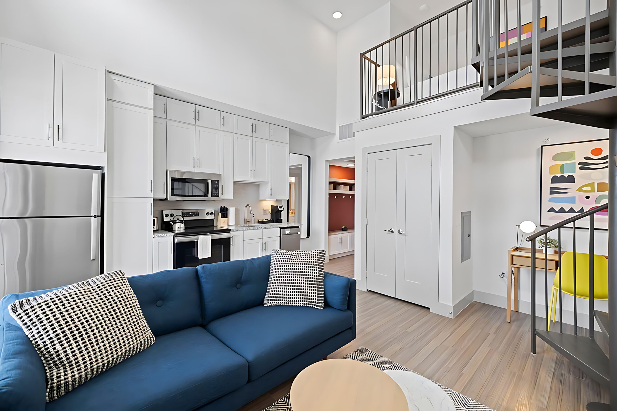 a living room with a blue couch and a kitchen