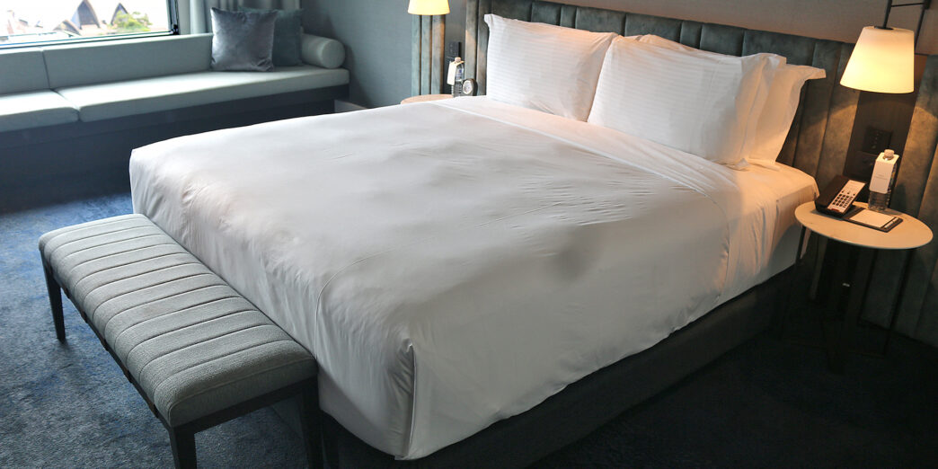 a bed with a bench and lamp