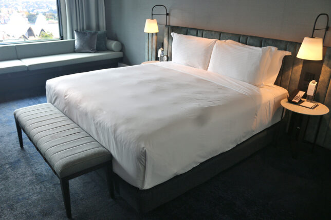 a bed with a bench and lamp