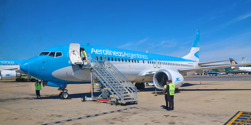 a plane with stairs and people in the background
