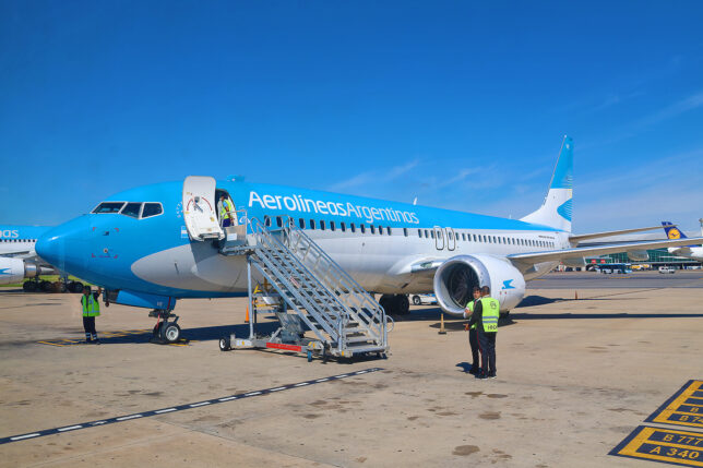 a plane with stairs and people in the background
