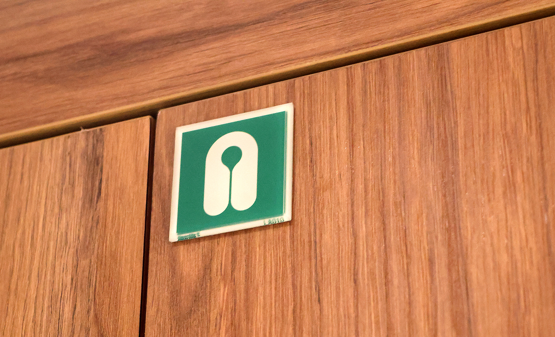 a green sign on a wood surface