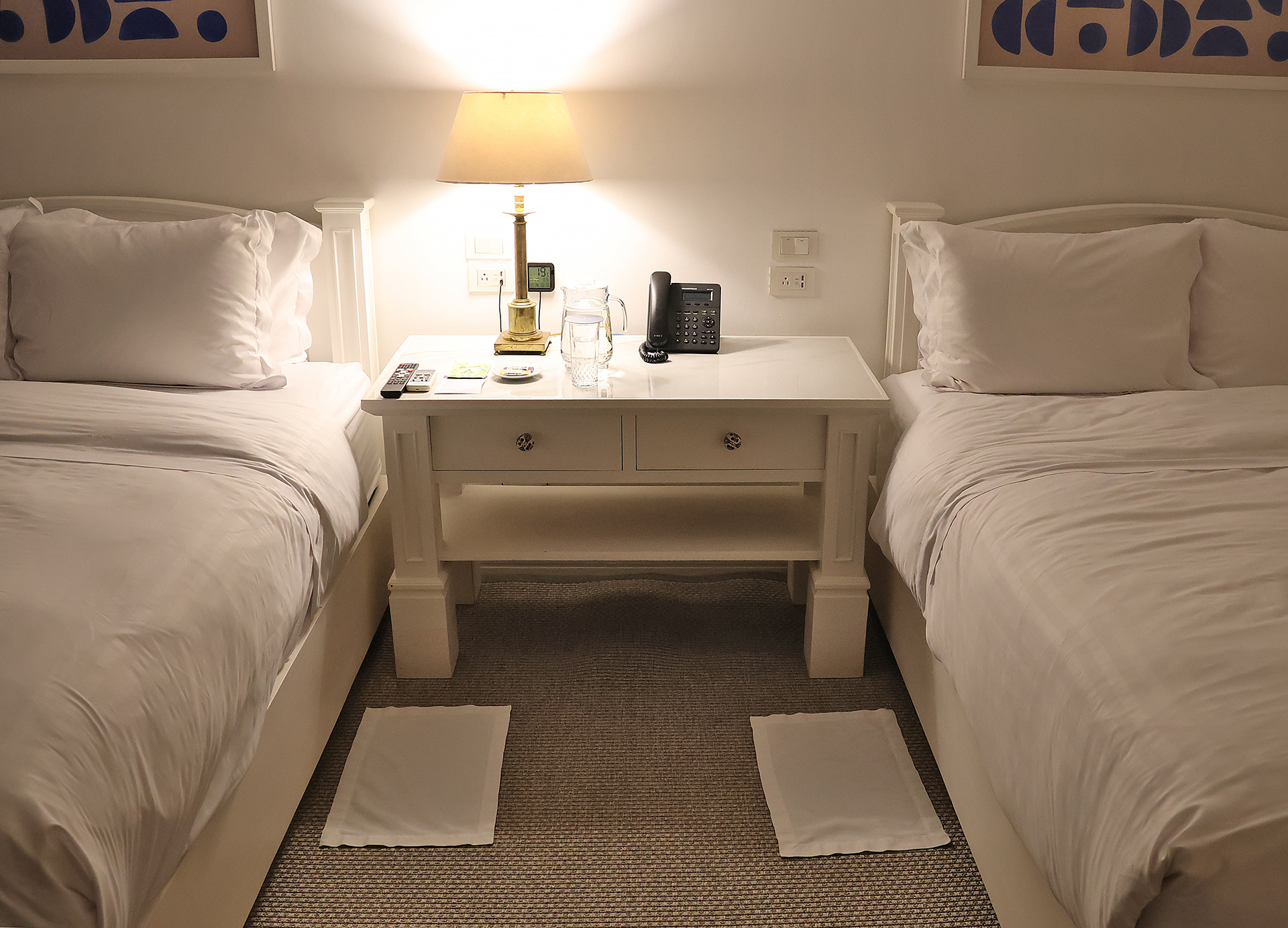 a room with two beds and a telephone on a table