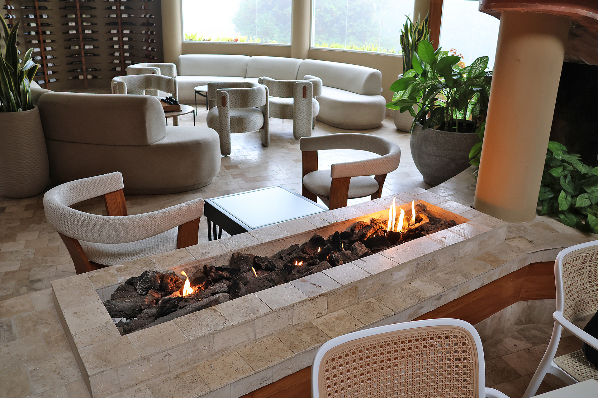 a fire pit in a room with chairs and a table
