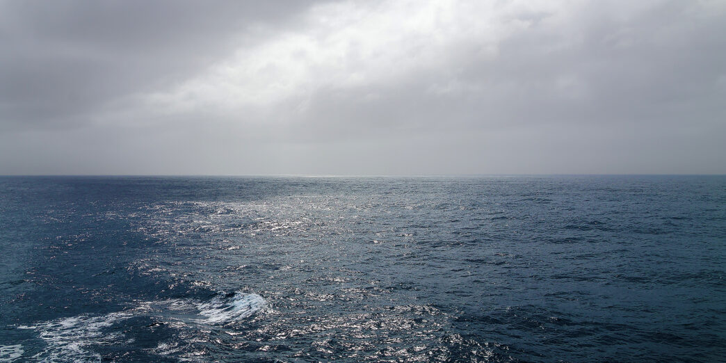 a body of water with clouds in the sky