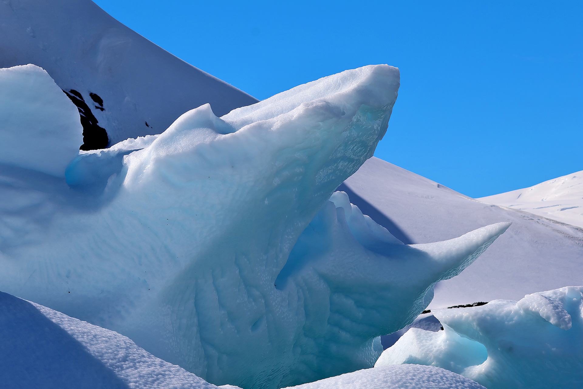 a snow covered mountain with a large iceberg