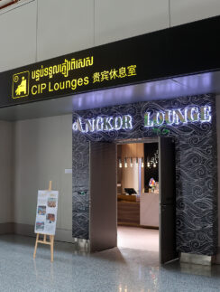 a sign with a lit up sign in front of a building