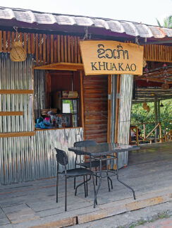 a small wooden building with a table and chairs