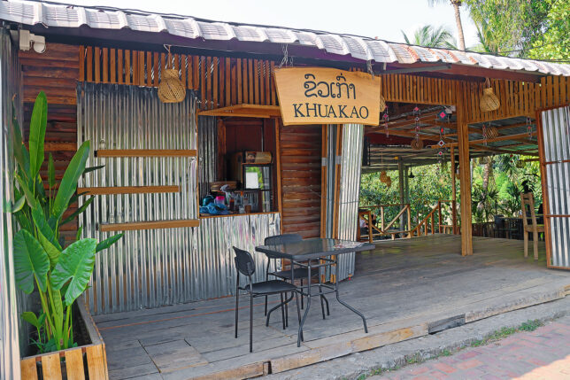 a small wooden building with a table and chairs
